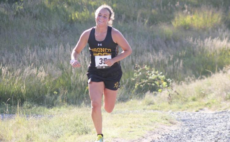 Callie Coble grins as she is cheered on coming up a hill on the Bridgeport course. Alex Moore