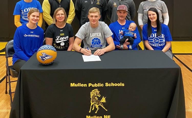 Mullen High School senior Clayton Moore signed his letter of intent to play basketball at the University of Nebraska-Kearney next year on Monday, Nov. 14. Pictured back, l-r: Tierston Moore, MPS Superintendent Chris Kuncl, MHS Boys Basketball Head Coach Brad Wright, MHS Boys Basketball Assistant Coach Daniel Young, Mercedes Garner. Front: Samantha Moore, Jennifer Moore, Clayton Moore, Lance Moore holding Cru Moore and Harlee Fischer.