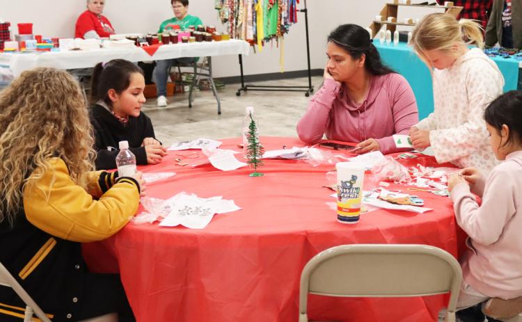 Riley Hegland, Luciana Gonzalez, Lorena Mercado, Danielle Peterson and Abigail Gonzalez work on building Christmas ornaments from Sandhill Fertilizer’s table at the Hooker County Community Center during Walkabout.